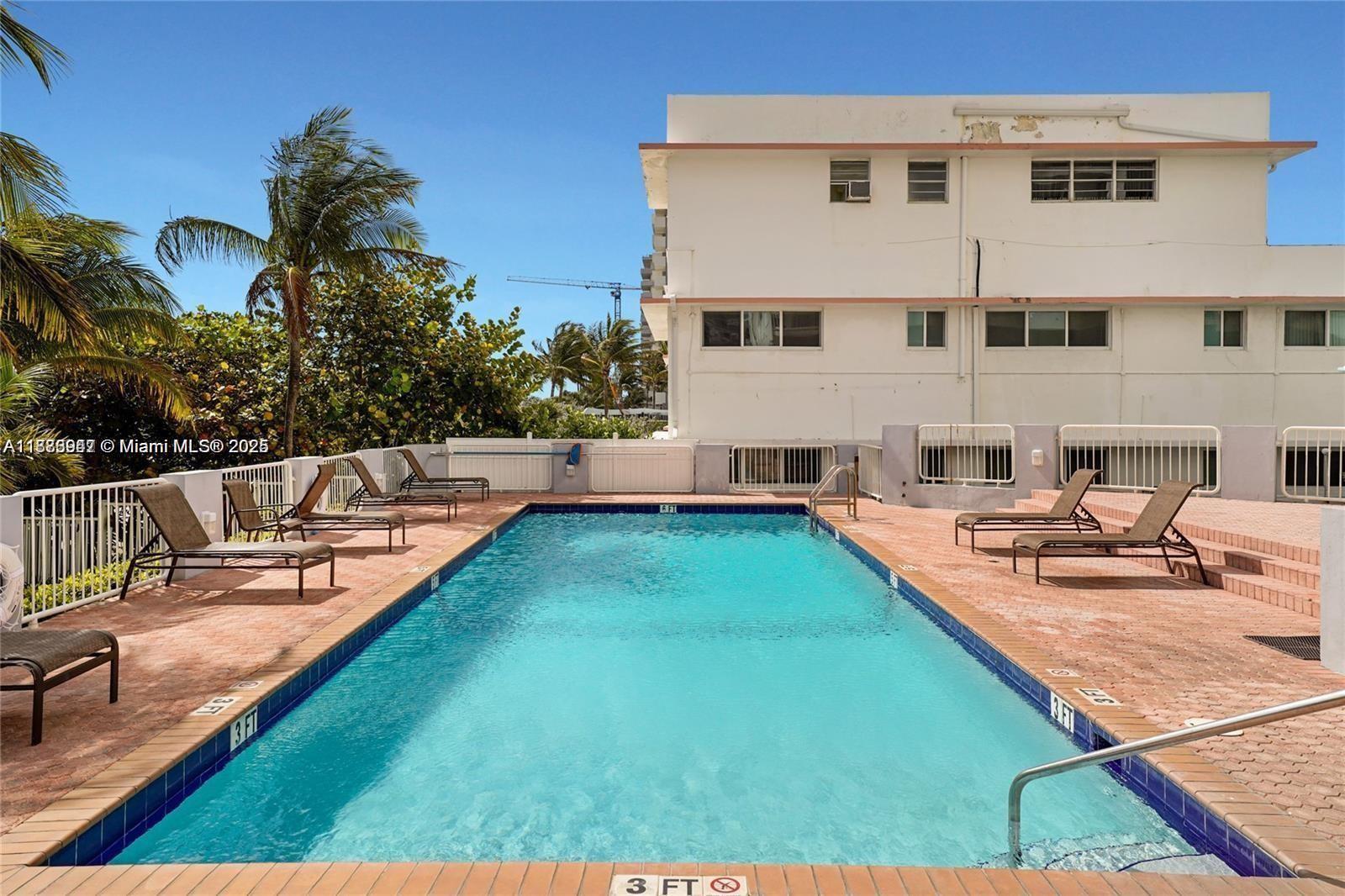 9341 Collins Avenue, Unit 806 Surfside, FL 33154 - Photo 18 of 27 a view of a backyard with couches chairs and fire pit