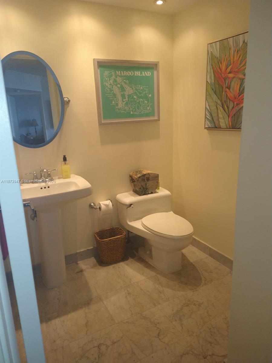 9341 Collins Avenue, Unit 806 Surfside, FL 33154 - Photo 10 of 27 a white toilet sitting next to a bathroom sink
