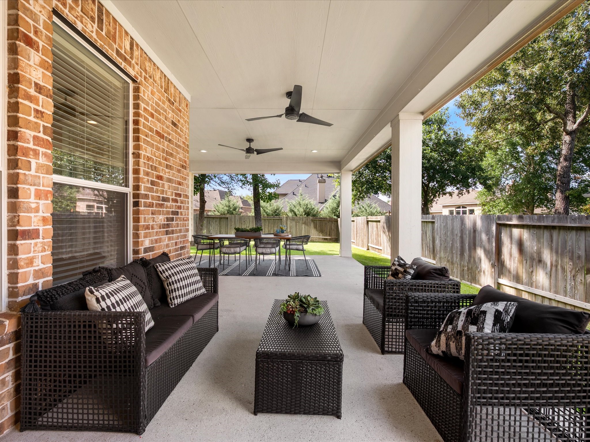 323 Arbor Ridge Lane Conroe, TX 77384 - Photo 32 of 40 This is the showstopper. Expansive covered patio with ceiling fans, room for a full lounge and a dining set, and a backyard wrapped in mature trees. Texas evenings were made for this.