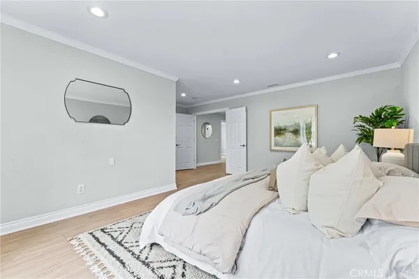 a bedroom with a large bed and wooden floor