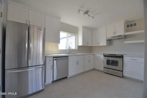 a kitchen with appliances a sink and a window