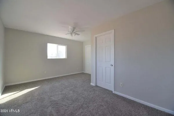 an empty room with a ceiling fan and a window