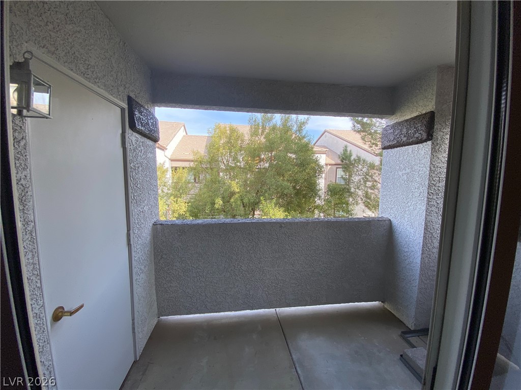 7255 West Sunset Road, Unit 2023 Las Vegas, NV 89113 - Photo 2 of 7 A private balcony offers serene views of mature trees and neighboring architecture.