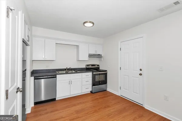 a kitchen with stainless steel appliances granite countertop a stove and a refrigerator