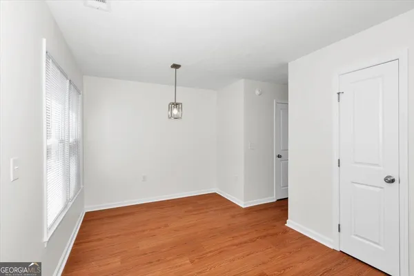 a view of empty room with wooden floor