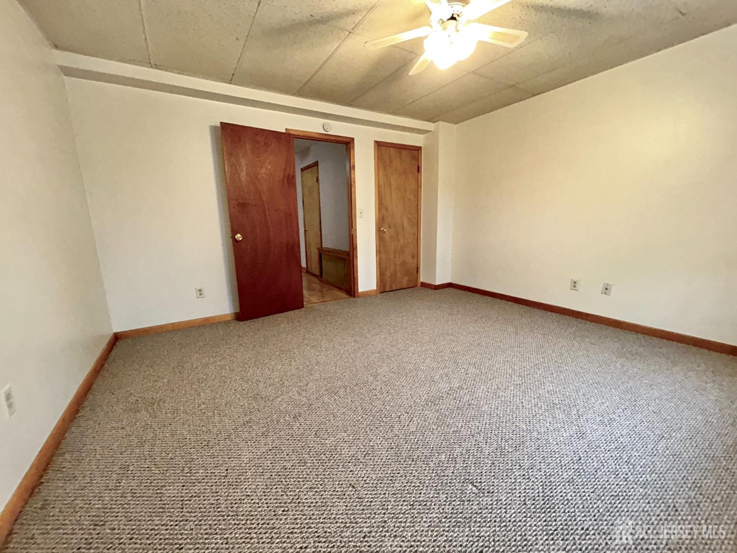 54 Loring Avenue, Unit 1 Edison, NJ 08817 - Photo 11 of 16 an empty room with a ceiling fan and carpet