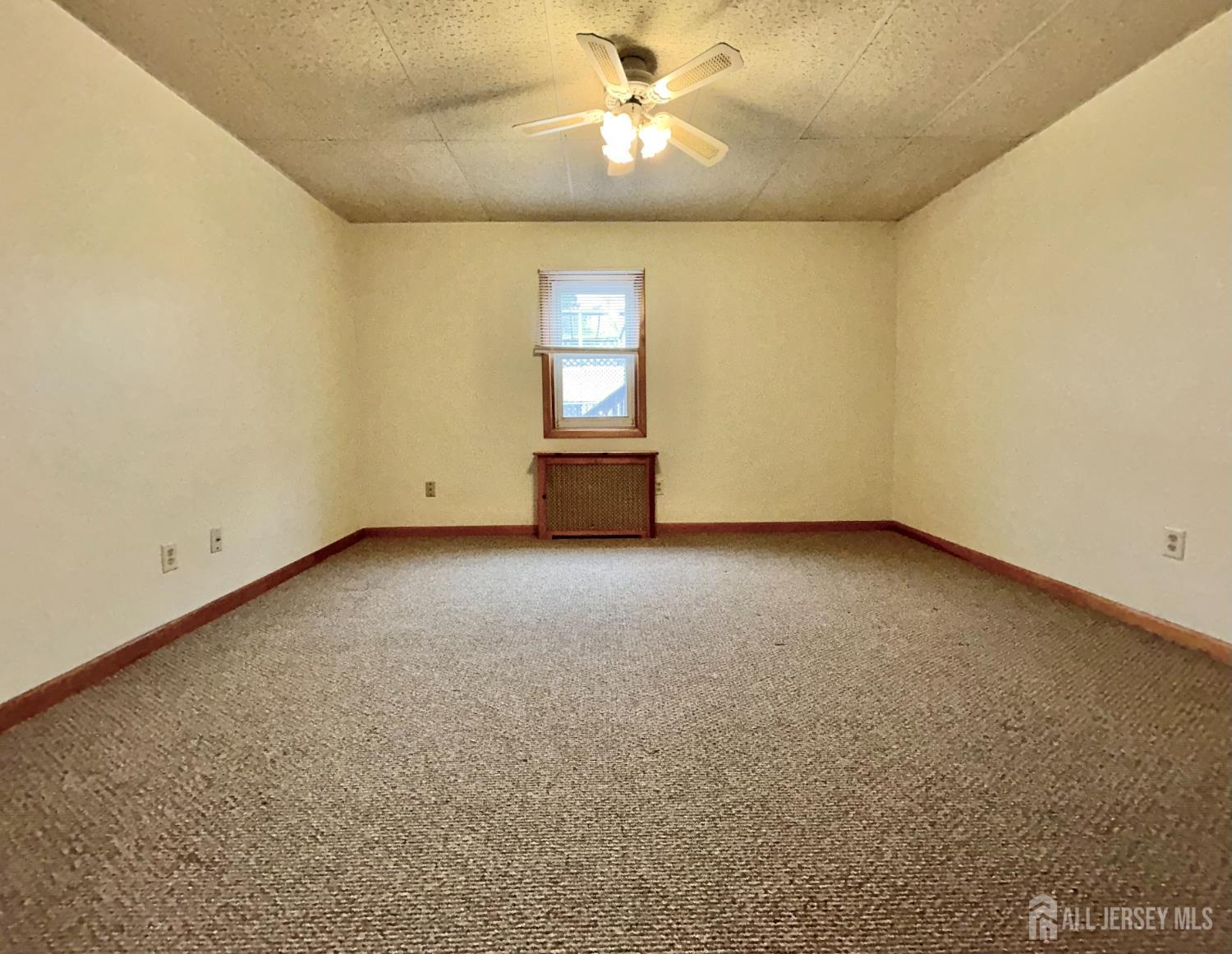 54 Loring Avenue, Unit 1 Edison, NJ 08817 - Photo 12 of 16 an empty room with windows and fan