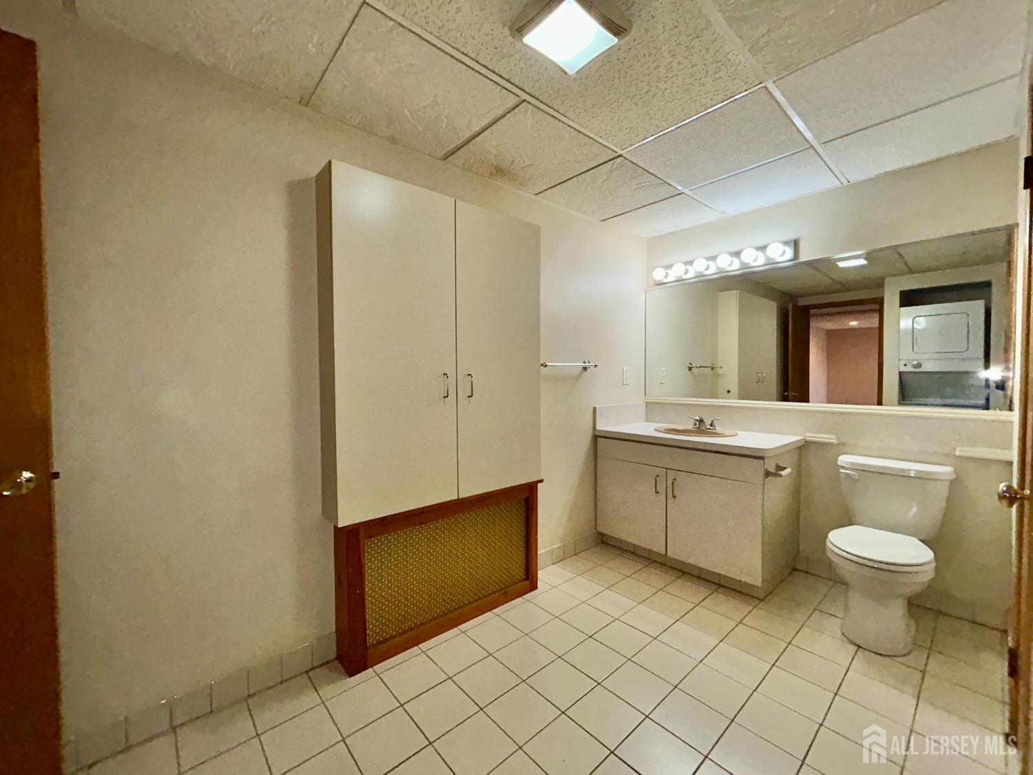 54 Loring Avenue, Unit 1 Edison, NJ 08817 - Photo 13 of 16 a bathroom with a sink a toilet and mirror