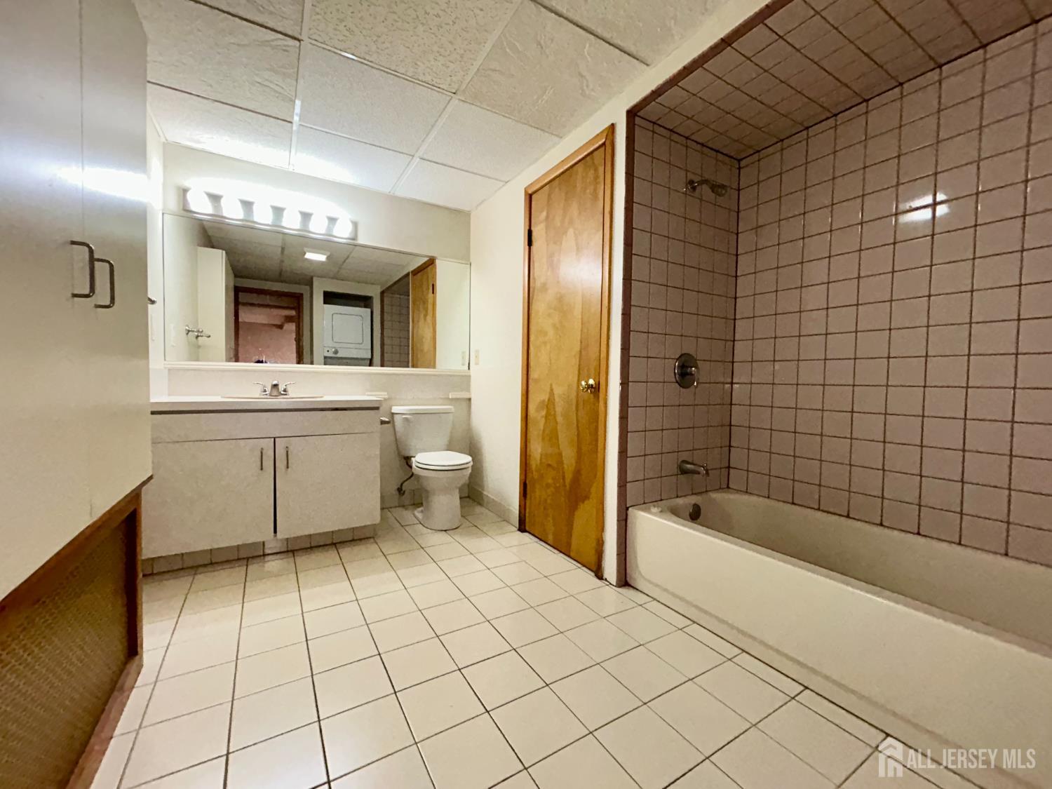 54 Loring Avenue, Unit 1 Edison, NJ 08817 - Photo 14 of 16 a bathroom with a bathtub a mirror a shower and a sink