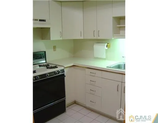 a kitchen with granite countertop white cabinets and stainless steel appliances