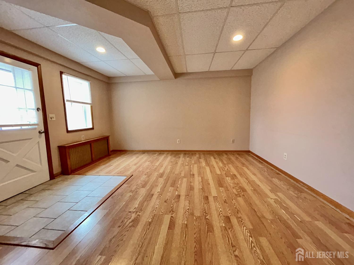54 Loring Avenue, Unit 1 Edison, NJ 08817 - Photo 3 of 16 an empty room with wooden floor and windows