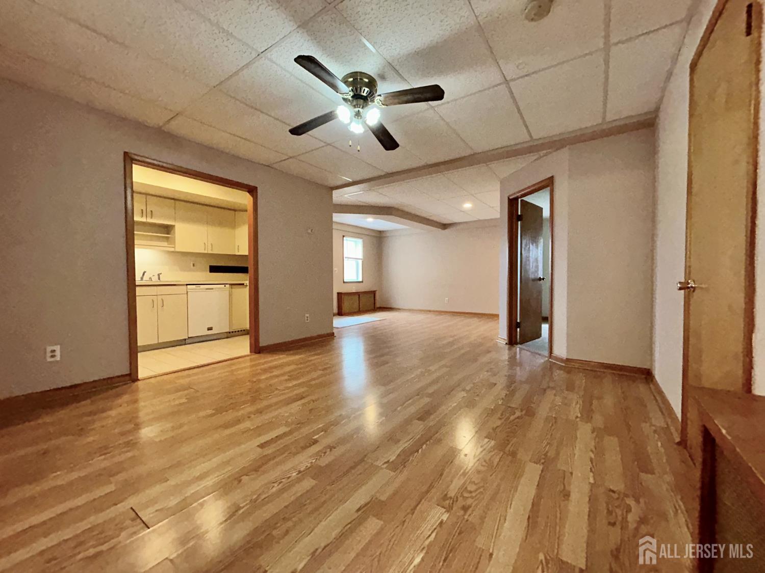 54 Loring Avenue, Unit 1 Edison, NJ 08817 - Photo 5 of 16 a view of an empty room with a window and wooden floor