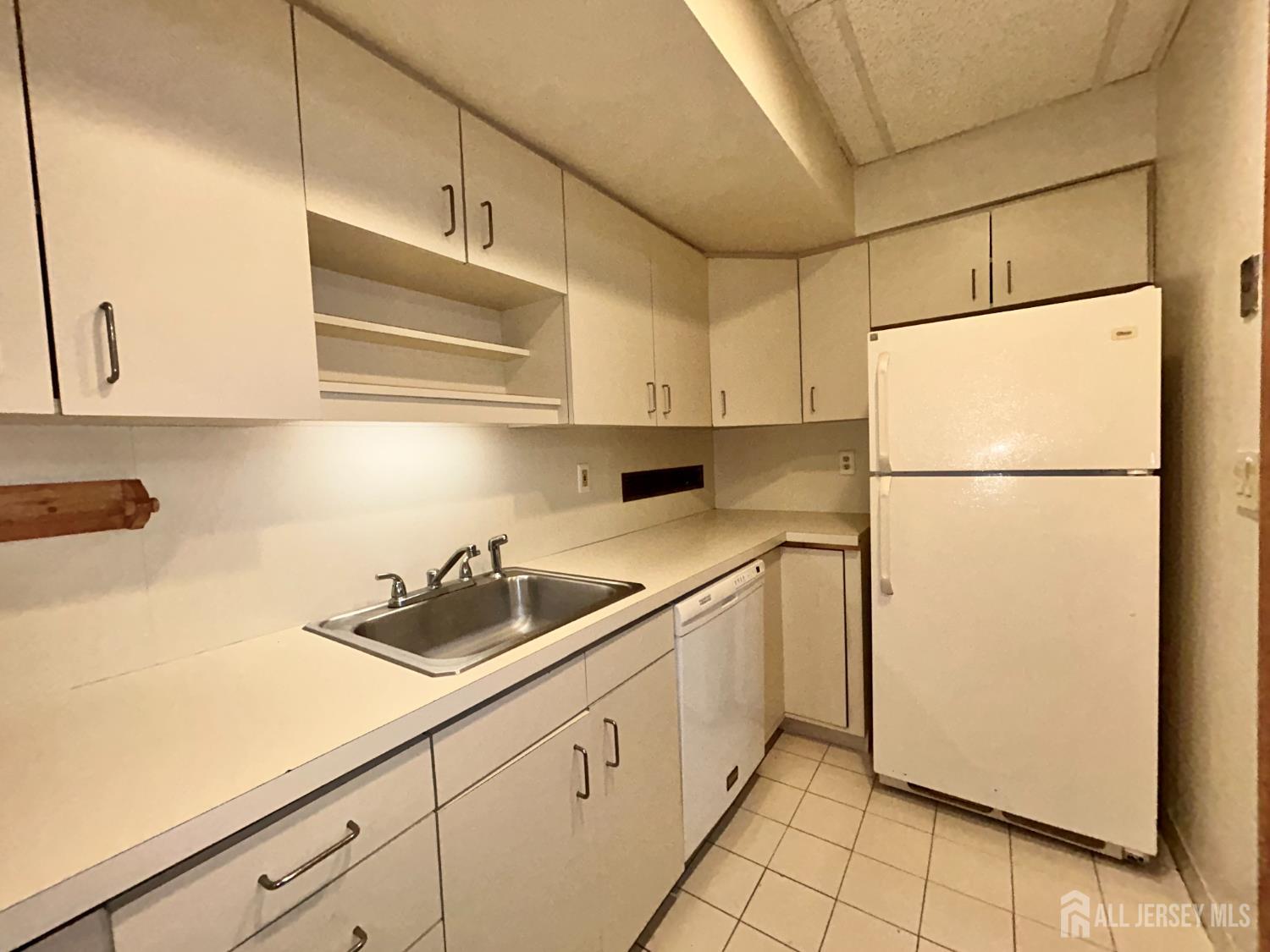 54 Loring Avenue, Unit 1 Edison, NJ 08817 - Photo 6 of 16 a kitchen with a refrigerator and a sink