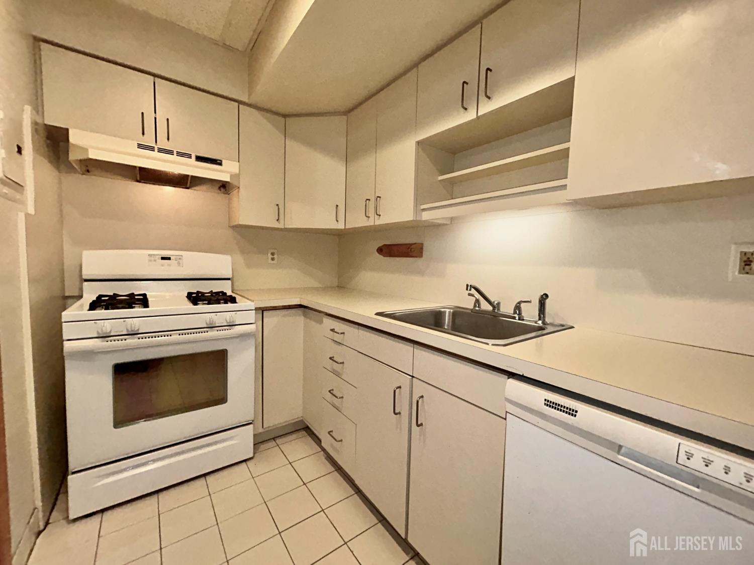54 Loring Avenue, Unit 1 Edison, NJ 08817 - Photo 7 of 16 a kitchen with stainless steel appliances granite countertop a sink a stove and cabinets