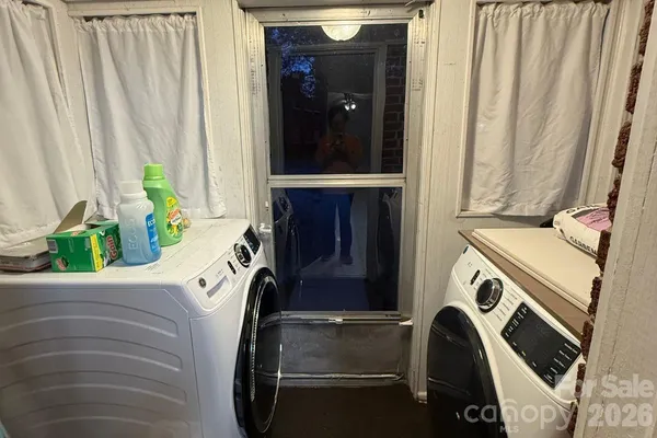 a view of backyard with wooden fence and large trees