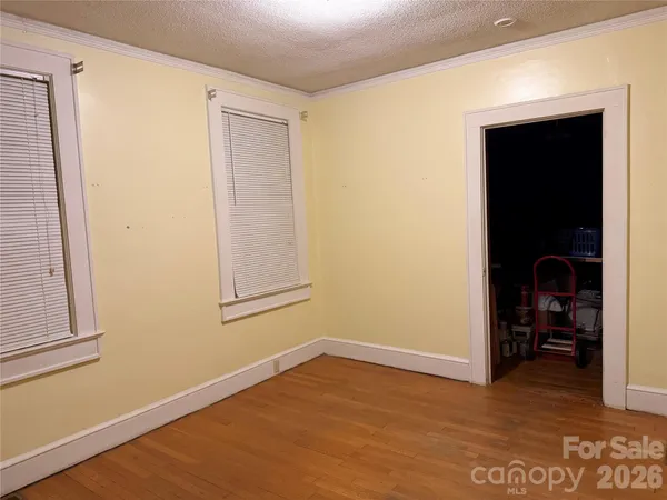 a view of empty room with wooden floor and closet