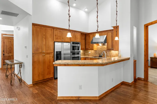 a kitchen with stainless steel appliances granite countertop a refrigerator a sink and a stove