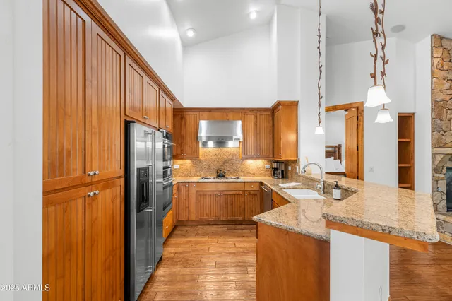 a kitchen with stainless steel appliances granite countertop a refrigerator a sink and a stove