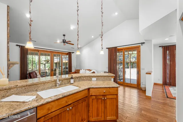 a kitchen with granite countertop a sink a counter top space and living room view