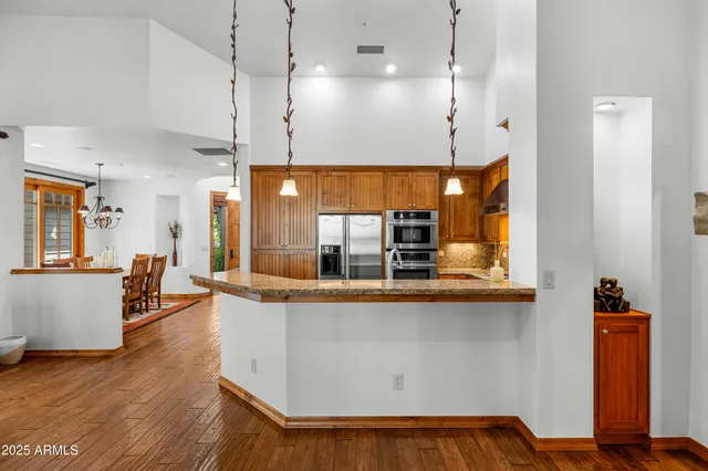 a view of a room with kitchen island stainless steel appliances wooden floor and window
