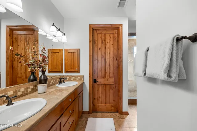 a bathroom with a double vanity sink a mirror and a shower