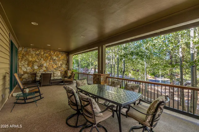 a view of a patio with table and chairs and floor to ceiling window with wooden floor
