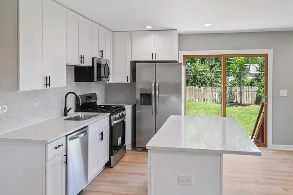 a kitchen with a sink a stove a refrigerator and a sink