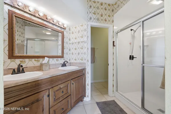 a bathroom with a double vanity sink mirror and shower