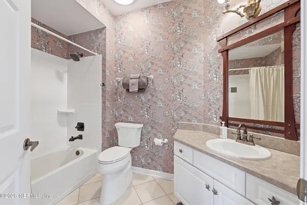 a bathroom with a granite countertop sink a toilet and a bathtub