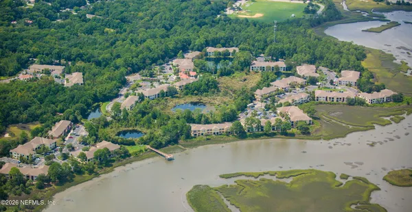 an aerial view of a house with a yard and lake view