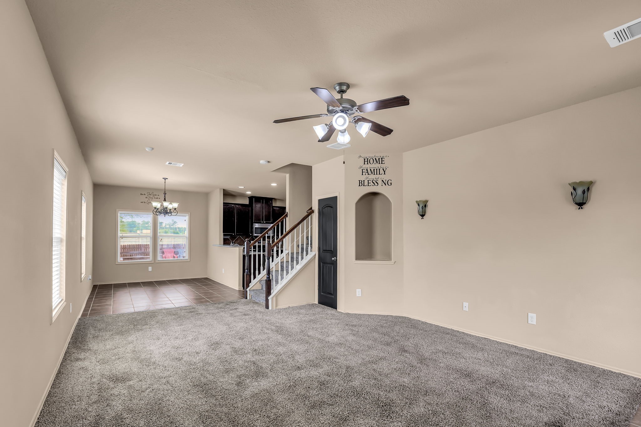 21307 Carleen Creek Trail Spring, TX 77379 - Photo 3 of 25 Alternate view of the living room which showcases a spacious, open-concept living and dining area with neutral-colored walls, carpeted flooring, and a ceiling fan.