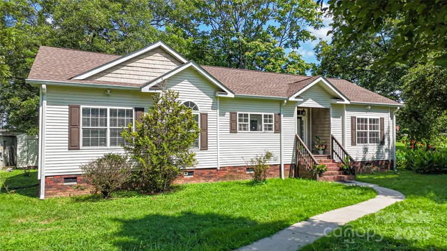 a front view of a house with a yard and green space