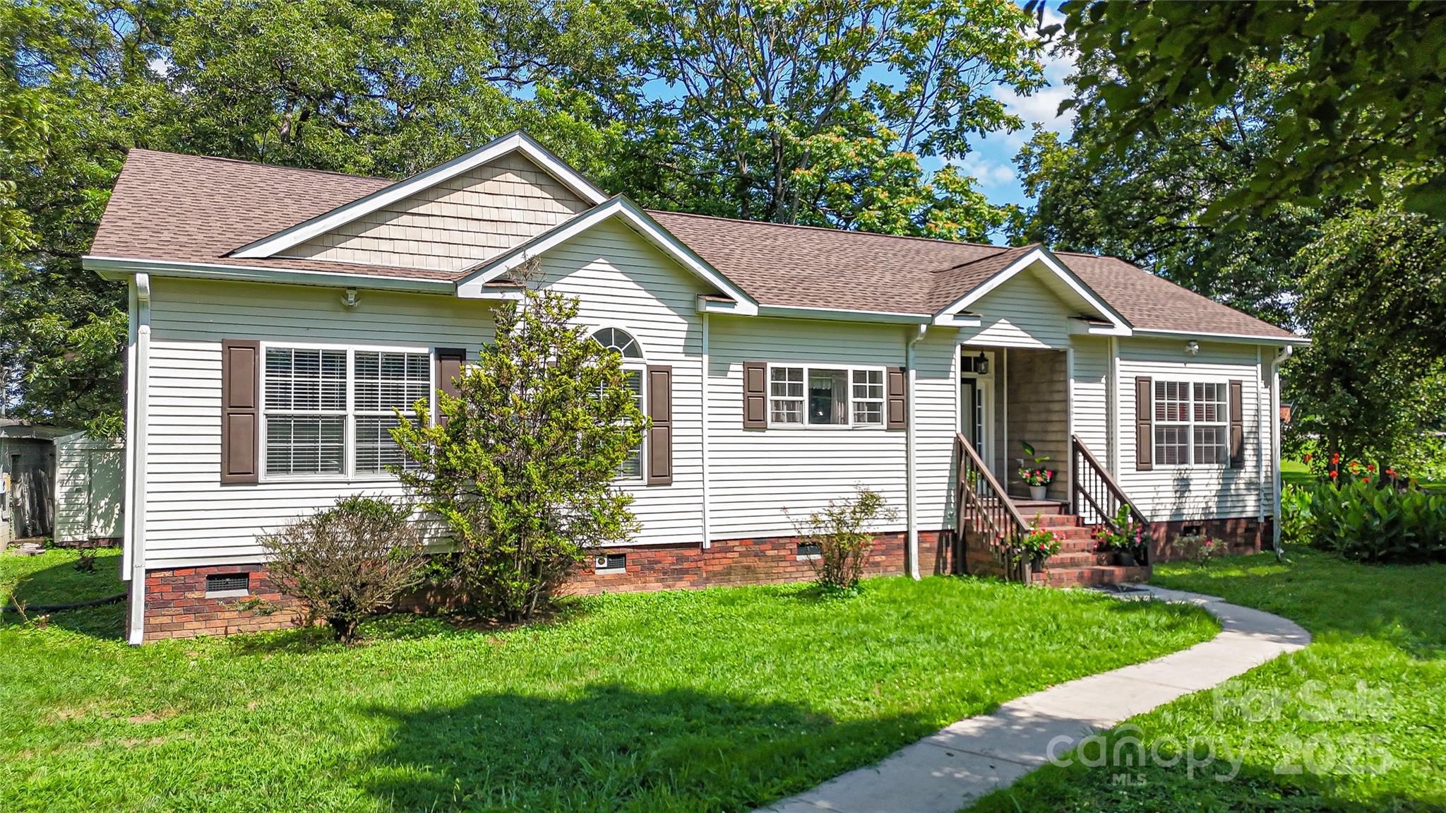 a front view of a house with a yard and green space