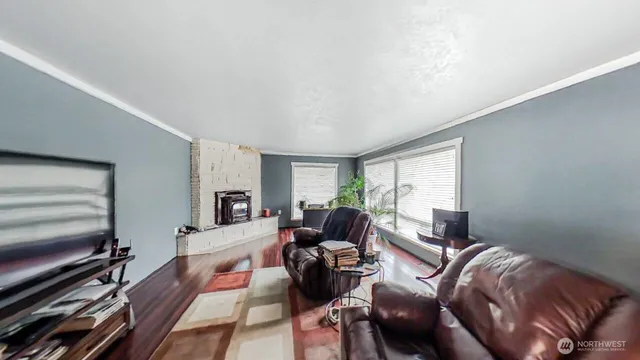 a living room with furniture fireplace and a large window