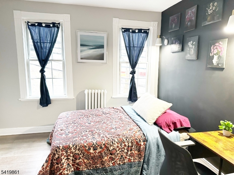 34 Duryea Street Newark, NJ 07103 - Photo 5 of 15 a bedroom with a bed a chandelier and a table in it