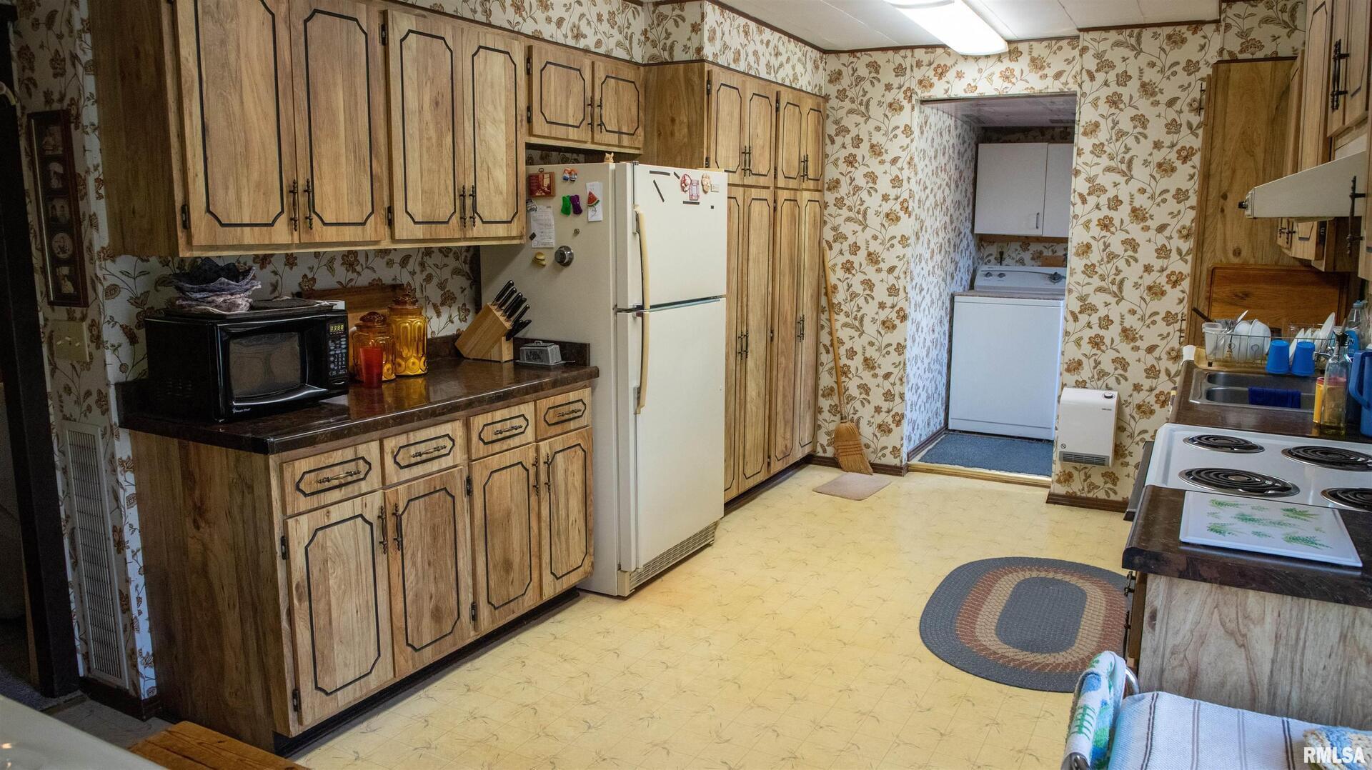2680 Highway 45 Vienna, IL 62995 - Photo 6 of 20 a kitchen with stainless steel appliances granite countertop a refrigerator a stove and a sink with wooden cabinets