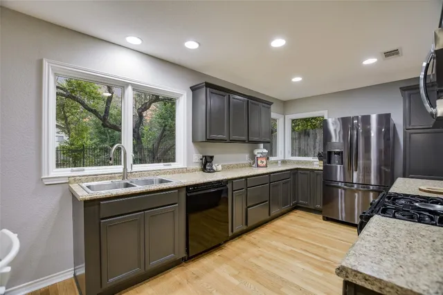a kitchen with stainless steel appliances granite countertop a sink stove and refrigerator