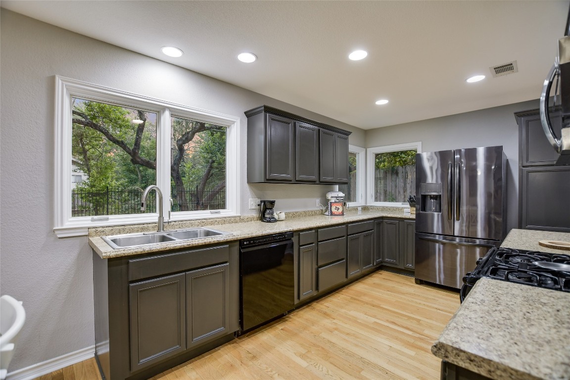 7615 Rockpoint Drive Austin, TX 78731 - Photo 18 of 30 a kitchen with stainless steel appliances granite countertop a sink stove and refrigerator