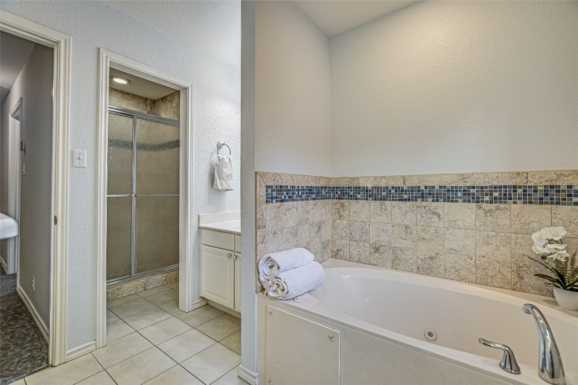 7615 Rockpoint Drive Austin, TX 78731 - Photo 25 of 30 a bathroom with a granite countertop bathtub and shower