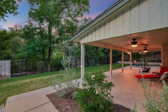 a view of a backyard with table and chairs under an umbrella
