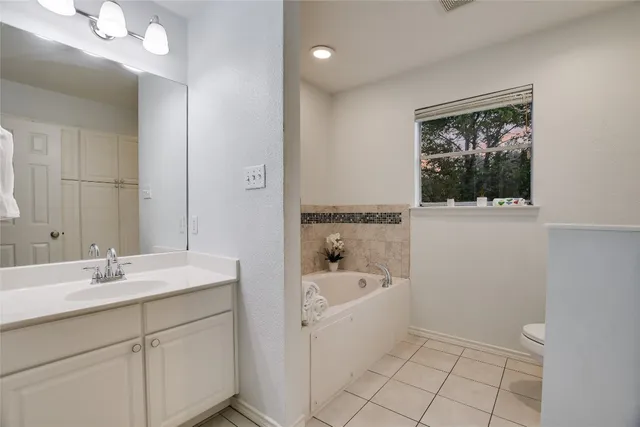 a bathroom with a sink a large mirror and a bathtub