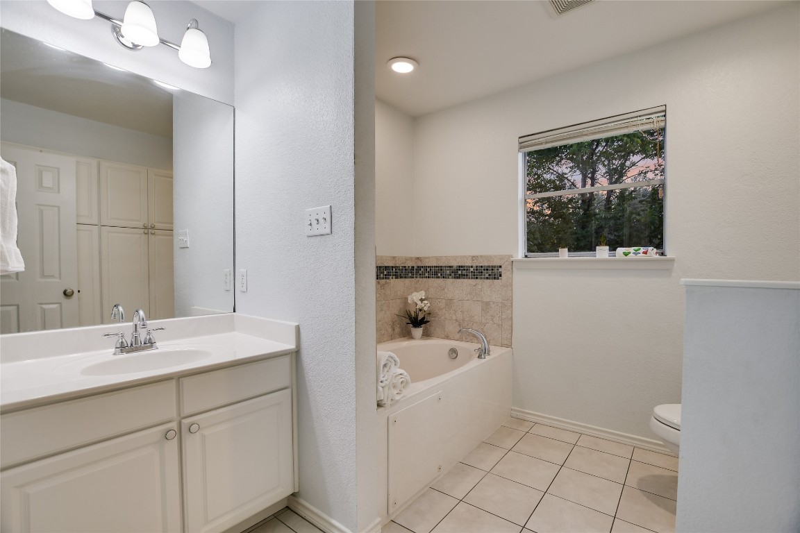 7615 Rockpoint Drive Austin, TX 78731 - Photo 7 of 30 a bathroom with a sink a large mirror and a bathtub