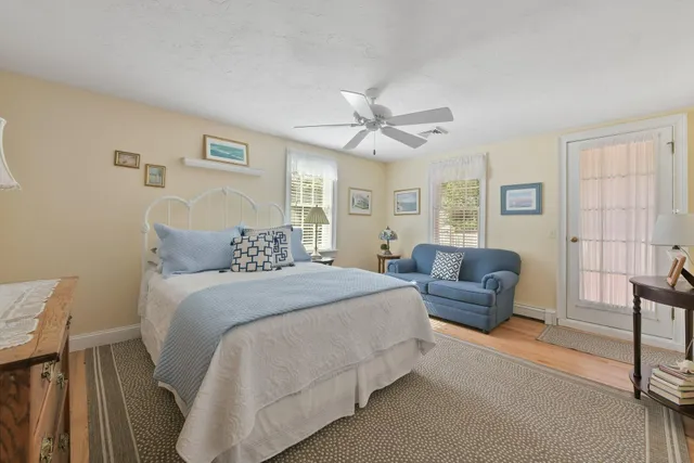 a spacious bedroom with a bed a couch and a chandelier