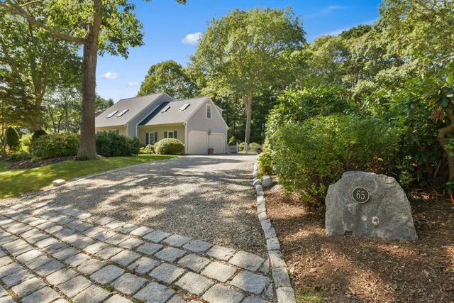 a view of a house with a yard and large tree