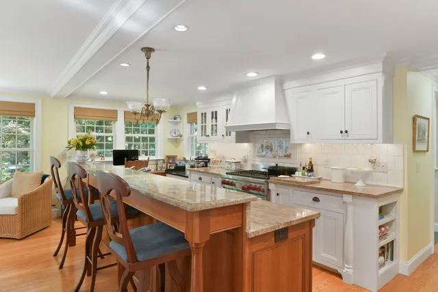 a kitchen with a stove a sink a dining table and chairs