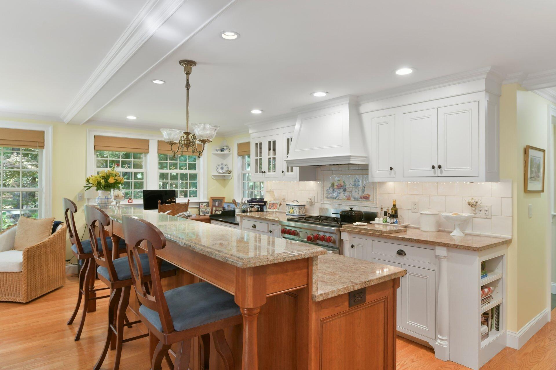 65 Tracey Road Cotuit, MA 02635 - Photo 10 of 36 a kitchen with a stove a sink a dining table and chairs