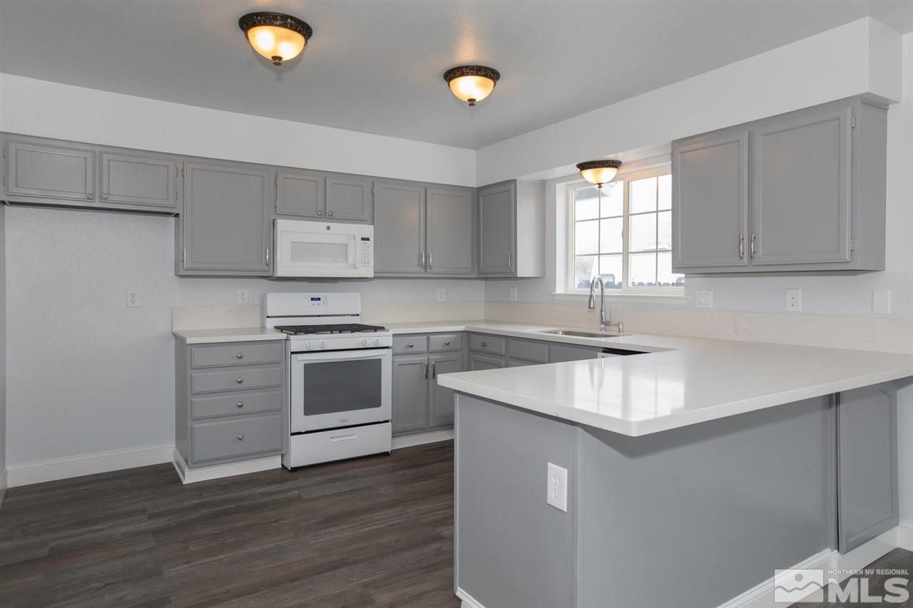 1220 Lattin Road Fallon, NV 89406 - Photo 6 of 25 a kitchen with granite countertop a sink stove and cabinets