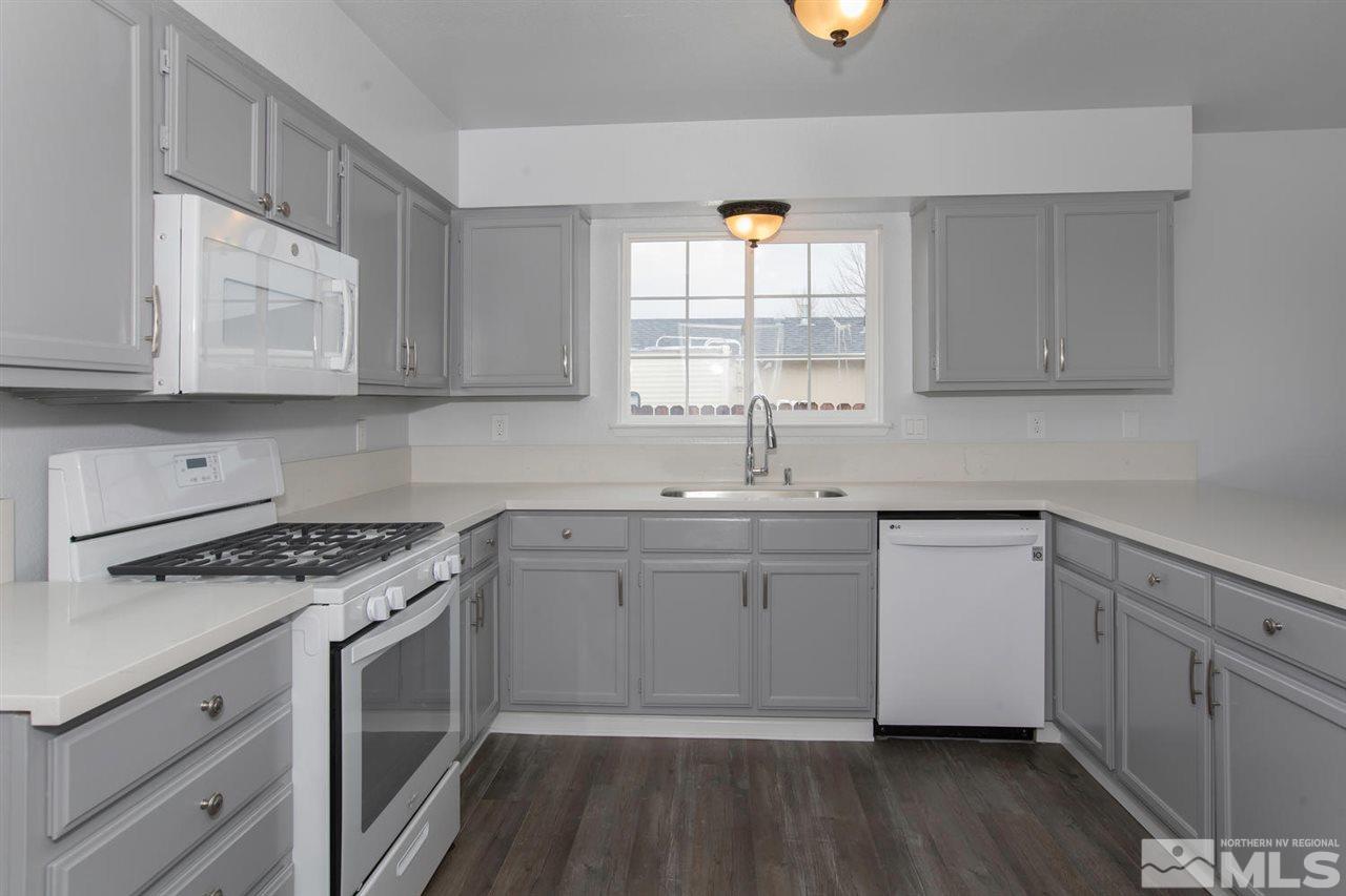 1220 Lattin Road Fallon, NV 89406 - Photo 7 of 25 a kitchen with stainless steel appliances granite countertop a sink a stove and a wooden floors