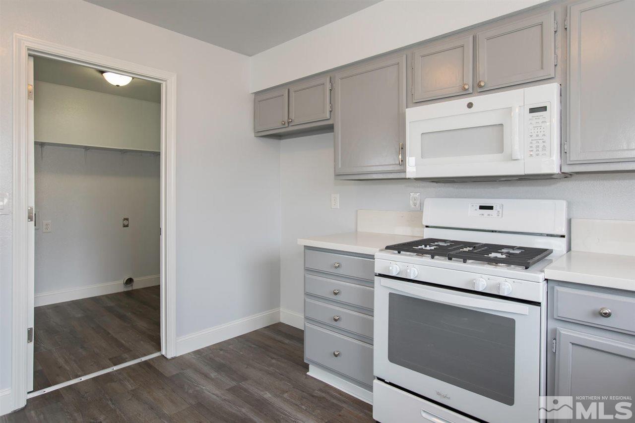 1220 Lattin Road Fallon, NV 89406 - Photo 8 of 25 a kitchen with cabinets appliances and wooden floor