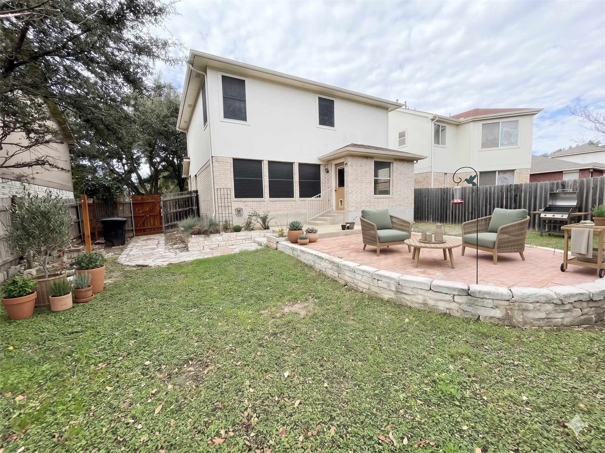 3638 Windhill Loop Round Rock, TX 78681 - Photo 30 of 32 Tiered backyard with a stone retaining wall, brick patio, and grass area
